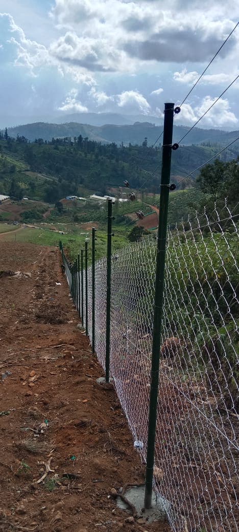 Solar fence line following steep terrain on a coffee estate boundary